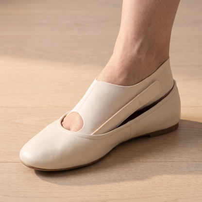 TrueToe strap worn inside a cream leather flat, the shoe sitting flat with no bulge